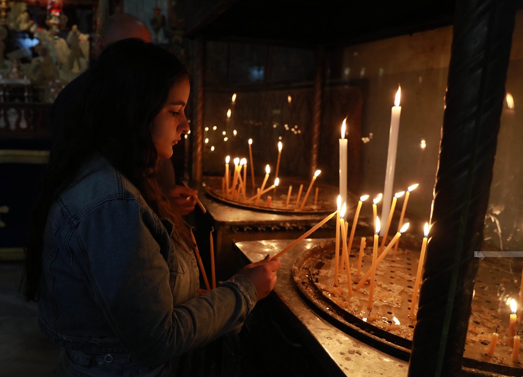 مواطنة تضيء الشموع في كنيسة المهد بمدينة بيت لحم (تصوير: أحمد مزهر/وفا)